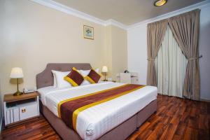 una camera da letto con un letto grande in una stanza di La Villa Suites Hotel a Doha