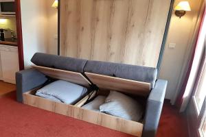 un sofá con almohadas sentado en una habitación en Appartement 2P Isola 2000, en Isola 2000