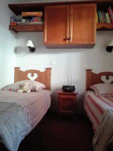 a bedroom with two beds with a teddy bear on the bed at Appartement 2P Isola 2000 in Isola 2000