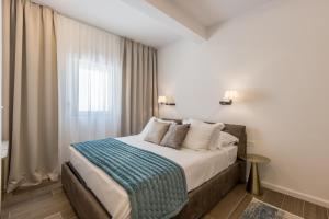 um quarto com uma cama com um cobertor azul em Villa Callista em Žrnovnica