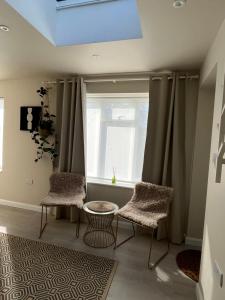 sala de estar con 2 sillas y ventana en Cosy 1 BR, 10min drive to Bath centre,Free parking en Bath