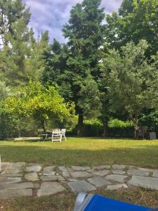 a white picnic table in a park with trees at Sani Garden House in Sani Beach