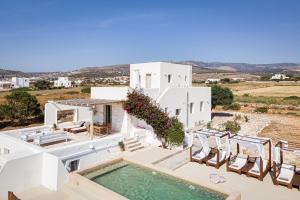 a villa with a swimming pool and chairs at Paros House Villa in Pounda