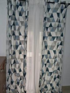 uma cortina de chuveiro numa casa de banho com padrões geométricos em Bel appartement à Liberté 6 extension em Dakar