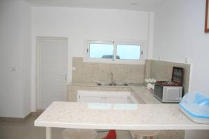uma cozinha com um balcão branco e um lavatório em Bel appartement à Liberté 6 extension em Dakar