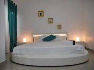 a large white bed in a bedroom with two lights at Bel appartement à Liberté 6 extension in Dakar