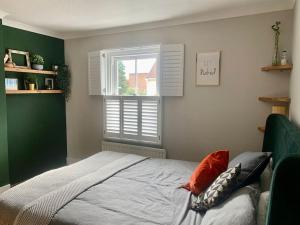 a bedroom with a bed and a window at 2 bed Victorian Cottage, log burner & garden room. in Dorney