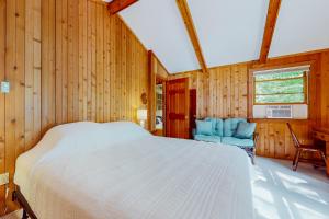 ein Schlafzimmer mit einem Bett und zwei blauen Stühlen in der Unterkunft Snowflake Cabin in Barnumville