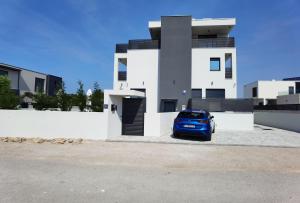 a blue car parked in front of a building at Villa Emperor in Srima