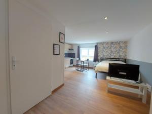 a bedroom with a bed and a table with a television at ° studio 2 - Lunéville centre ° in Lunéville