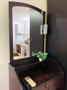 een spiegel bovenop een dressoir met een afstandsbediening bij For rent condo popular T8 fl9 in Thung Si Kan