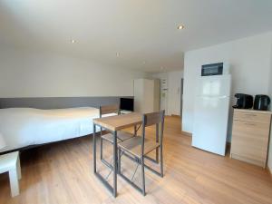 a bedroom with a bed and a table and a kitchen at ° studio 2 - Lunéville centre ° in Lunéville