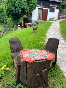 a bench made out of a tree stump with a blanket at Seosko domaćinstvo Vidović in Banja Luka