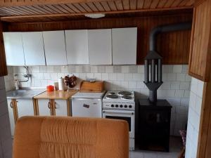 a kitchen with white cabinets and a stove top oven at Seosko domaćinstvo Vidović in Banja Luka