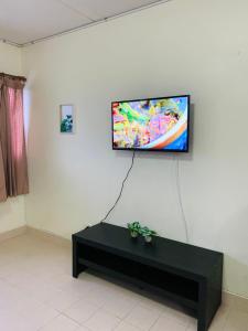 TV de pantalla plana colgada en una pared blanca en For rent condo popular T8 fl9 en Thung Si Kan