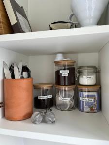 a shelf with jars and other kitchen utensils at Cosy 1 BR, 10min drive to Bath centre,Free parking in Bath