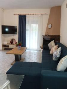 a living room with a blue couch and a table at The Sunny House in Kritharia