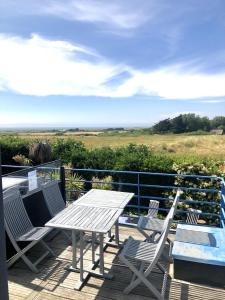 einen Tisch und Stühle auf einer Terrasse mit Aussicht in der Unterkunft Gîte de Charme avec vue Mer in Saint-Jean-Trolimon