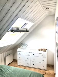 ein Schlafzimmer mit einem Dachfenster und einer Kommode im Dachgeschoss in der Unterkunft Gîte de Charme avec vue Mer in Saint-Jean-Trolimon