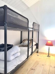 Saint-Jean-TrolimonにあるGîte de Charme avec vue Merの二段ベッド2組(ランプ付)が備わる客室です。