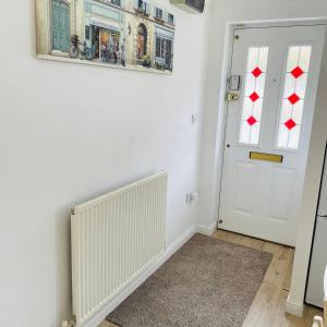 um quarto com um radiador e uma porta branca em Mezzo House- Entire property em Coventry