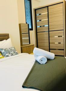 a bedroom with two beds and a towel on the bed at ASTRA at Opus Residences Kuala Lumpur in Kuala Lumpur