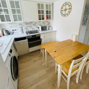 Mezzo House- Entire property في كوفينتري: مطبخ مع طاولة خشبية وطاولة وكراسي خشبية