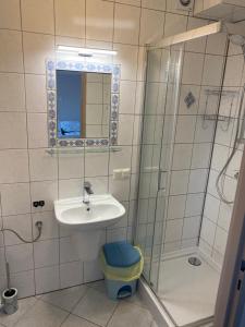 La salle de bains est pourvue d'un lavabo et d'une douche. dans l'établissement Pokoje Gościnne " AWIA ", à Łeba