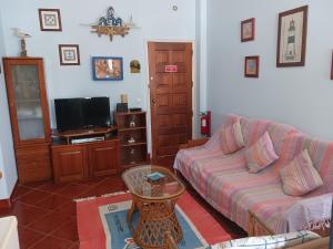 a living room with a couch and a tv at Villa Vau in Portimão