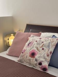 a bed with two pillows and a pillow with flowers at Ristella Home in Monopoli
