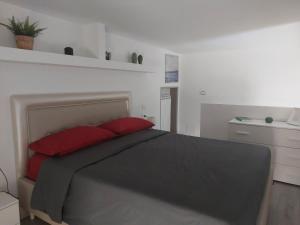 1 dormitorio con 1 cama con 2 almohadas rojas en LA MAISON D&D en Margherita di Savoia