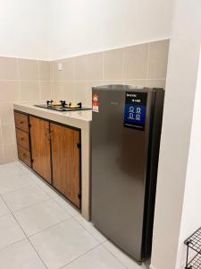 a kitchen with a black refrigerator next to a counter at Ariesya Homestay 2 in Ipoh +8 photos