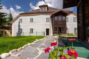 una gran casa blanca con flores delante en Podenhaus en Bad Aussee