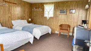 a hotel room with two beds and a television at Rachel's Motel and Cottages in Surrey