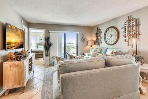 a living room with a couch and a tv at Caprice 401 in St. Pete Beach