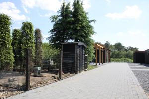 une clôture avec un arbre sur le côté d'une route dans l'établissement B&B Hoeve de Veldmaat, à Haaksbergen