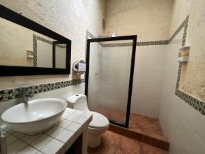 a bathroom with a white sink and a toilet at Casa del viajero colonial in Antigua Guatemala