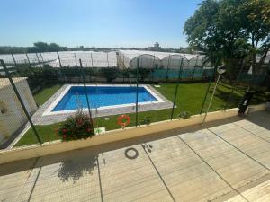 a fence with a swimming pool in a yard at Home Chipiona Cadiz Parking in Chipiona