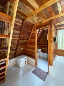 um quarto no sótão com paredes de madeira e um aparelho branco em Belas Águas Mairiporã em Mairiporã