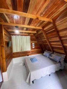 Cama en habitación con techo de madera en Belas Águas Mairiporã en Mairiporã