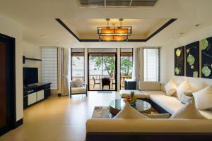 a living room with a couch and a table at 2 Bedrooms Beachfront Pool Villas in Bang Tao Beach