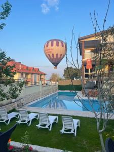 a hot air balloon flying over a swimming pool at Sirius Boutique Otel Pamukkale in Pamukkale
