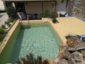 a pool of water in the backyard of a house at Gîte Zoé in Chervettes