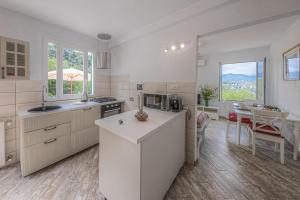 eine Küche mit weißen Schränken und ein Esszimmer mit einem Tisch in der Unterkunft Casa Otti by PortofinoHomes in Santa Margherita Ligure