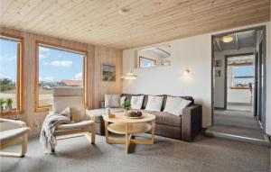 BjerregårdにあるAmazing Home In Hvide Sande With Wifiのリビングルーム(ソファ、テーブル付)