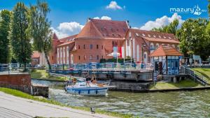 una barca in un canale di fronte a un edificio di Gizycko.warszawska5 a Giżycko