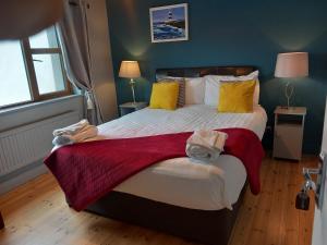 um quarto com uma cama grande e toalhas em Baywatch Inn em Dingle