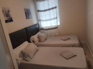 a small room with two beds and a window at PISO PLAZA CABECEO in Jerez de la Frontera