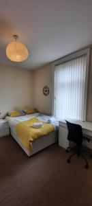 a bedroom with a bed and a desk and a chair at City Centre Ensuite Home - Free parking, near Uni & Hospital in Sunderland
