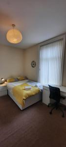 1 dormitorio con cama, escritorio y ventana en City Centre Ensuite Home - Free parking, near Uni & Hospital en Sunderland